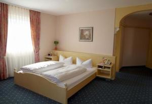 a bedroom with a large bed and a window at Hotel KRONE Kressbronn am Bodensee in Kressbronn am Bodensee