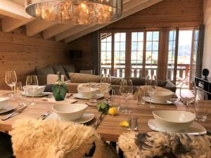 a wooden table with glasses and plates on it at Chalet ELK Lenk in Lenk