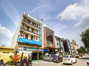 um edifício numa rua da cidade com carros estacionados em Green Lotus Residency Dwarka em Nova Deli