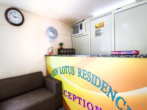 Green Lotus Residency Dwarka في نيودلهي: غرفة بها أريكة وساعة على الحائط