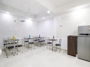 d'une salle à manger avec des tables, des chaises et un réfrigérateur. dans l'établissement Green Lotus Residency Dwarka, à New Delhi