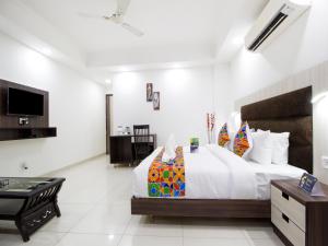 1 dormitorio con 1 cama grande y TV en Green Lotus Residency Dwarka en Nueva Delhi