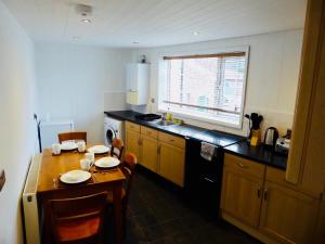 a kitchen with a wooden table and a kitchen with a table and chairs at Vermuyden Apartment in Epworth