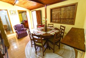 uma sala de jantar com uma mesa de madeira e cadeiras em Cantinho dos Coqueiros em Olímpia