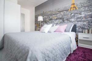 1 dormitorio con 1 cama blanca grande con almohadas rosas en Apartman Ante, en Vinkovci