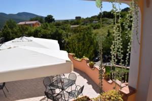 een balkon met een tafel, stoelen en planten bij Country House B&B Antica Dimora Del Sole in Camerota
