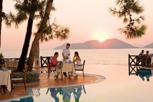 a group of people sitting around a table by a pool at Liberty Lykia in Oludeniz +37 photos