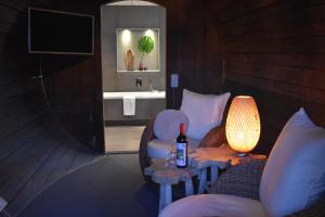 a bathroom with a sink and a table with a bottle of wine at Hotel De Vrouwe van Stavoren in Stavoren