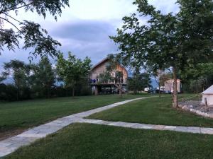 a white house with a tree in front of it at Lake Shkodra Resort in Grilë