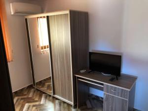 Zimmer mit einem TV auf einem Schreibtisch mit Spiegel in der Unterkunft Pensiunea Cosmin in Corbu