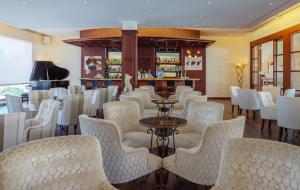 un restaurante con sillas blancas y un bar en La Quinta Menorca by PortBlue Boutique - Adults Only en Cala'n Bosch
