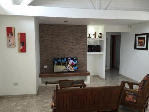 a living room with a tv on a brick wall at Casa Patagónica Los Frutales in El Calafate