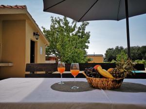 a table with two glasses of wine and a basket of fruit at Holiday Retreat Apartment - Zadar in Zadar