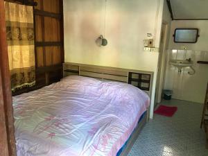 ein Schlafzimmer mit einem Bett und einem Waschbecken in einem Zimmer in der Unterkunft Blue Lotus Resort in Baan Tai
