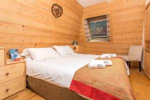 a bedroom with a bed and a chair in a cabin at Le Paradis 18 - Chamonix All Year in Chamonix