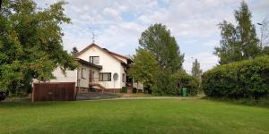 a white house with a fence and a yard at Polku Apartaments in Imatra