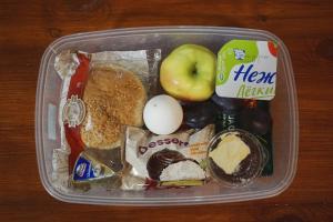 a lunch box with an egg an apple and other foods at Lenin Street Hostel in Tiraspol