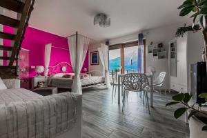 1 dormitorio con paredes rosas, mesa y cama en B&B Da Melissa, en Vercana