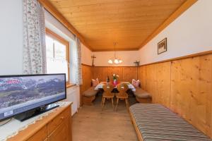 a dining room with a table and chairs and a tv at Oberdeutinghof in Saalfelden am Steinernen Meer
