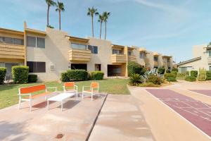 a row of apartment buildings with benches and palm trees at Camelback House in Scottsdale