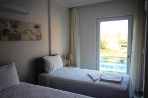 a hotel room with two beds and a window at Dalyan Villa MoonLight in Dalyan