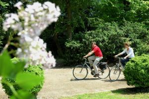 twee mensen fietsen in een park bij AuxR Etape La Maison du Randonneur in Auxerre