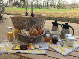 a picnic table with a basket of bread and juice at Cabane Aligoté in Saint-Albain