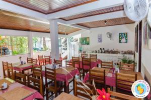 ein Restaurant mit Tischen und Stühlen und einer Theke in der Unterkunft Pousada Manga Rosa- Arraial in Arraial d'Ajuda