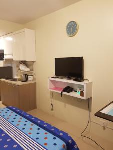 eine Küche mit einem TV an der Wand in der Unterkunft Hermione's Haven at Horizon 101 Cebu in Cebu City
