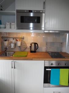 a kitchen with a sink and a stove top oven at Hayloft in Pulborough