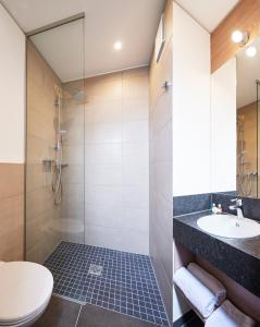 a bathroom with a shower and a toilet and a sink at Hotel New In in Ingolstadt