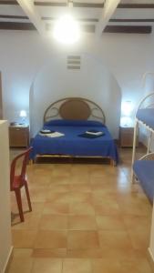 a bedroom with a blue bed and a chair at Case Vacanze Levante in Vulcano