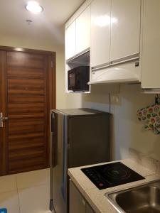 eine Küche mit einem Edelstahlkühlschrank und weißen Schränken in der Unterkunft Hermione's Haven at Horizon 101 Cebu in Cebu City