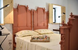 a bed with a wooden headboard with a basket on it at Fatuaria in Cisternino