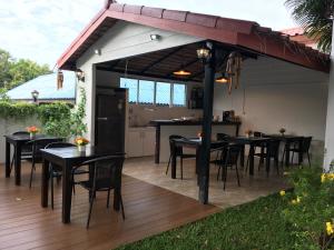 奈汉海滩维维小屋别墅度假酒店的遮阳篷下带桌椅的天井