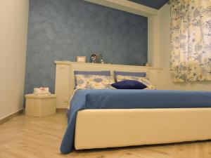 ein Schlafzimmer mit einem Bett mit blauer Bettwäsche und einer blauen Wand in der Unterkunft MarEtna in Giardini-Naxos