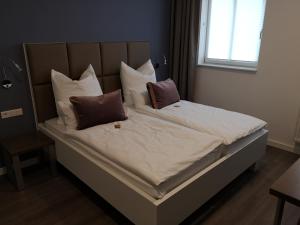 a bed with several pillows on it in a bedroom at Trip Inn PostApart Aschaffenburg in Aschaffenburg