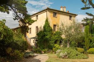 een oud huis met een trap in een tuin bij Agriturismo San Martino in Montepulciano