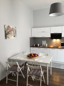 a white kitchen with a white table and chairs at Ametyst Hostel in Krakow