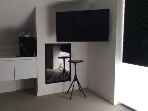 Lebbeke的住宿－Biotina，一间带电视和凳子的客厅