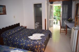 a bedroom with a bed with a robe on it at Hotel Palmas del Sol in Asuncion