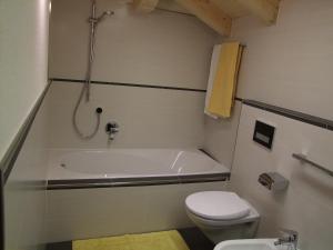 a bathroom with a tub and a toilet and a sink at App. Birkenheim in Valdaora