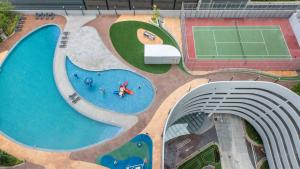 an overhead view of a swimming pool with a tennis court at Encorp Marina Suites By Iconic Bliss in Nusajaya