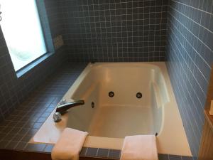 a bath tub with two towels in a bathroom at RiverTree Inn & Suites in Clarkston