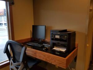 einen Schreibtisch mit einem Computer, einem Monitor und einem Drucker in der Unterkunft RiverTree Inn & Suites in Clarkston