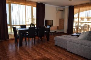 un salon avec une table, des chaises et un canapé dans l'établissement Sea Club Sarafovo Apartments, à Bourgas