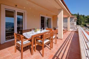 a wooden table and chairs on the patio of a house at Casa di Giorgio in Jelsa