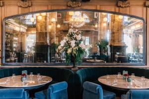 two tables in a restaurant with a vase of flowers at The Scotsman Hotel in Edinburgh