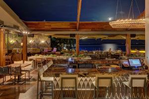 un restaurant avec un bar doté de tables et de chaises dans l'établissement Family apt with garden next to the sea, à Athènes