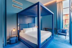 a bedroom with a canopy bed and a desk at Room Mate Bruno, Rotterdam in Rotterdam